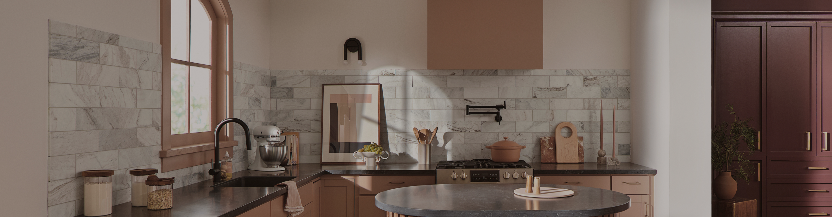 Gray and white tile backsplash in a kitchen with black countertops